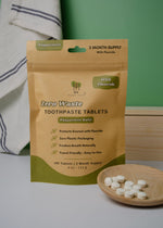 Load image into Gallery viewer, Package of zero waste toothpaste tablets with tablets on a wooden plate.
