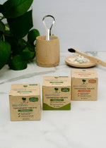 Load image into Gallery viewer, Three boxes of Zero Waste toothpaste tablets on a white surface with a plant and bamboo cup in the background.
